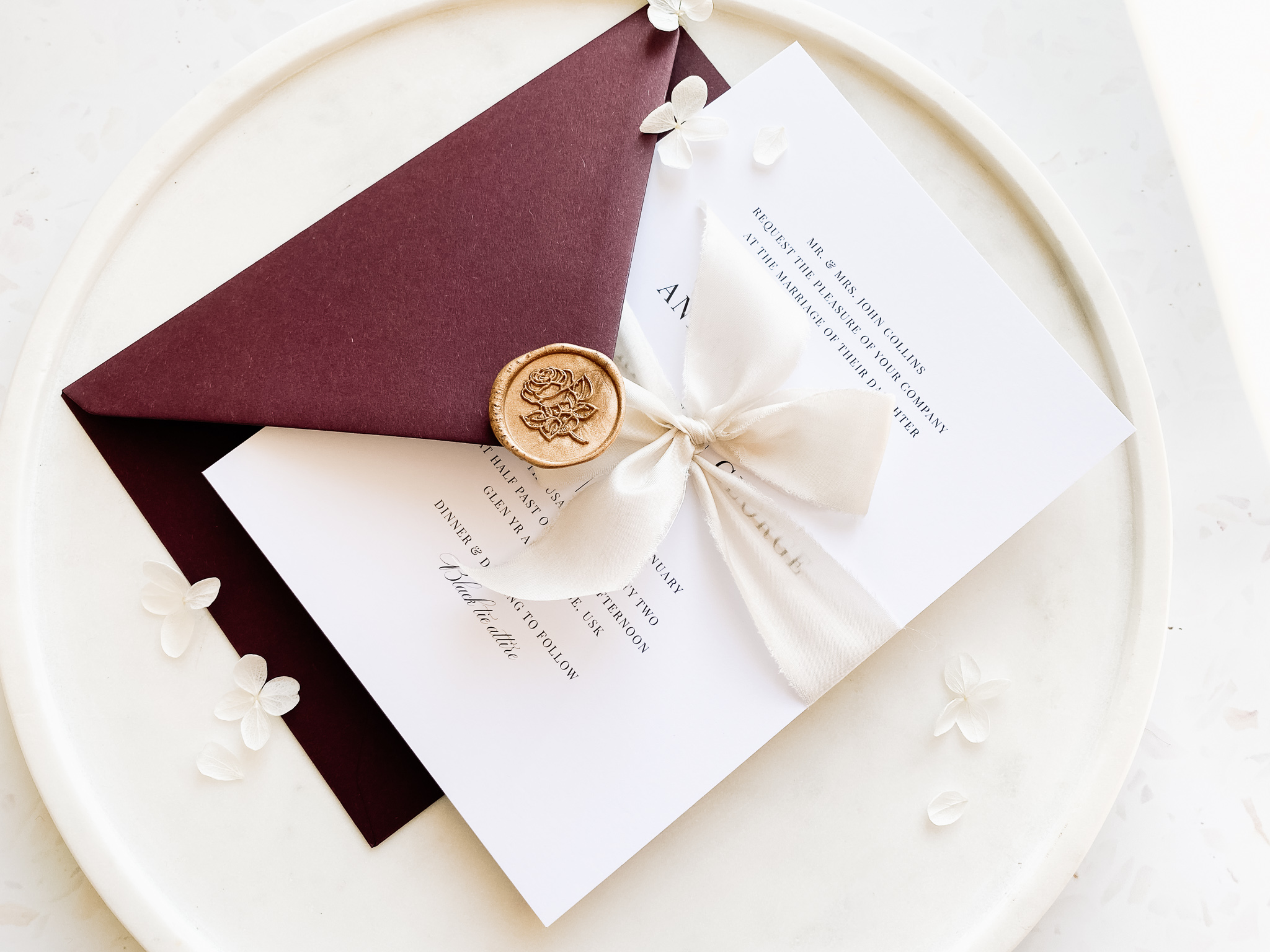 Burgundy envelope and gold wax seal.