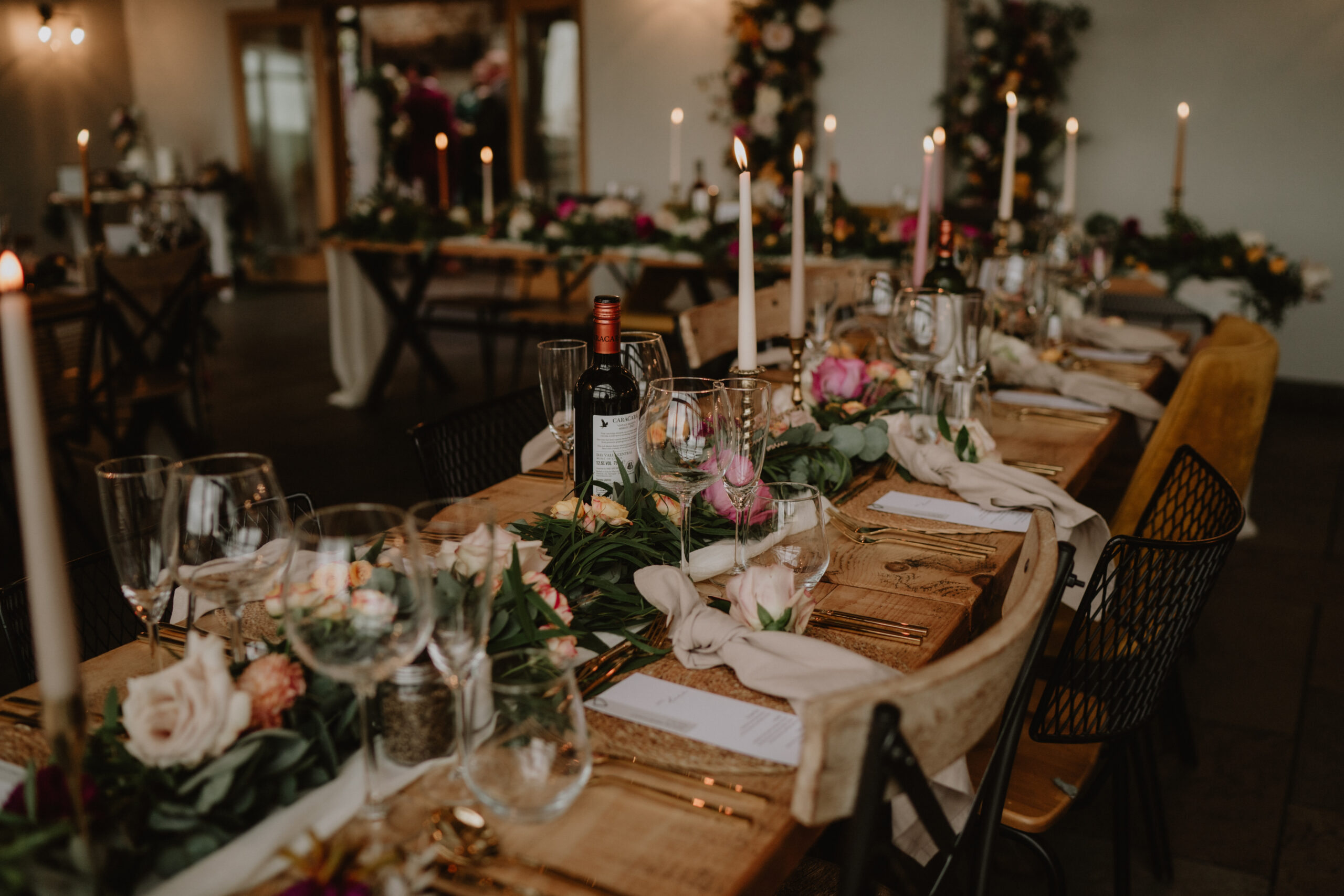 A rustic yet modern, industrial wedding table styled with gold cutlery, brass candlesticks and trailing flowers.