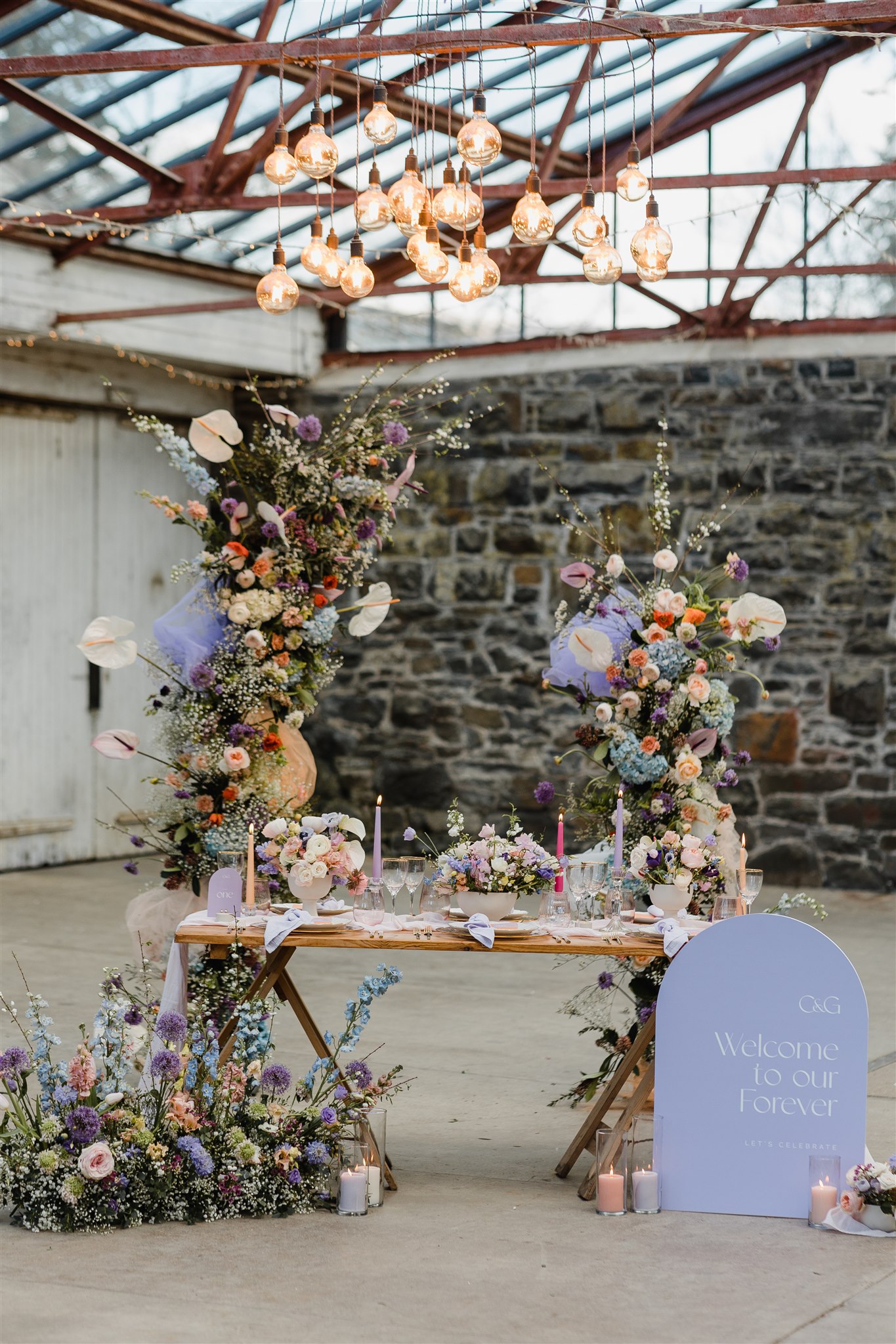 Lilac table setting with arch shaped sign and an abundance of pastel florals.