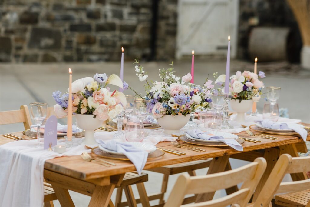 Pastel flowers in modern bowls, chiffon table runner, gold cutlery and lilac napkins.
